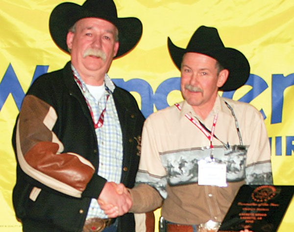 Trophy plaque sponsor Rob Tanner presenting Committee of the Year (Medium Rodeo) winner representative Jake Wiebe on behalf of the La Crete rodeo committee
